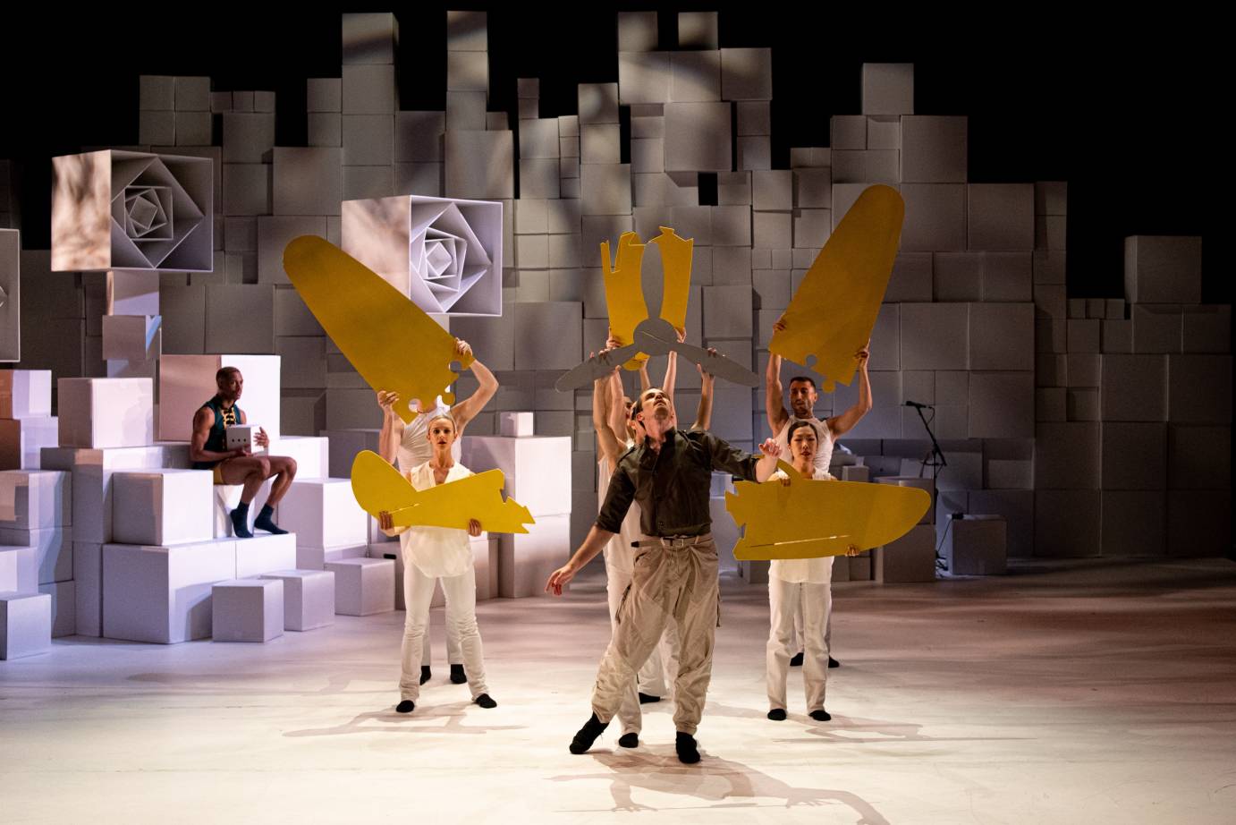 The cast holds pieces of yellow to suggest a plane in motion